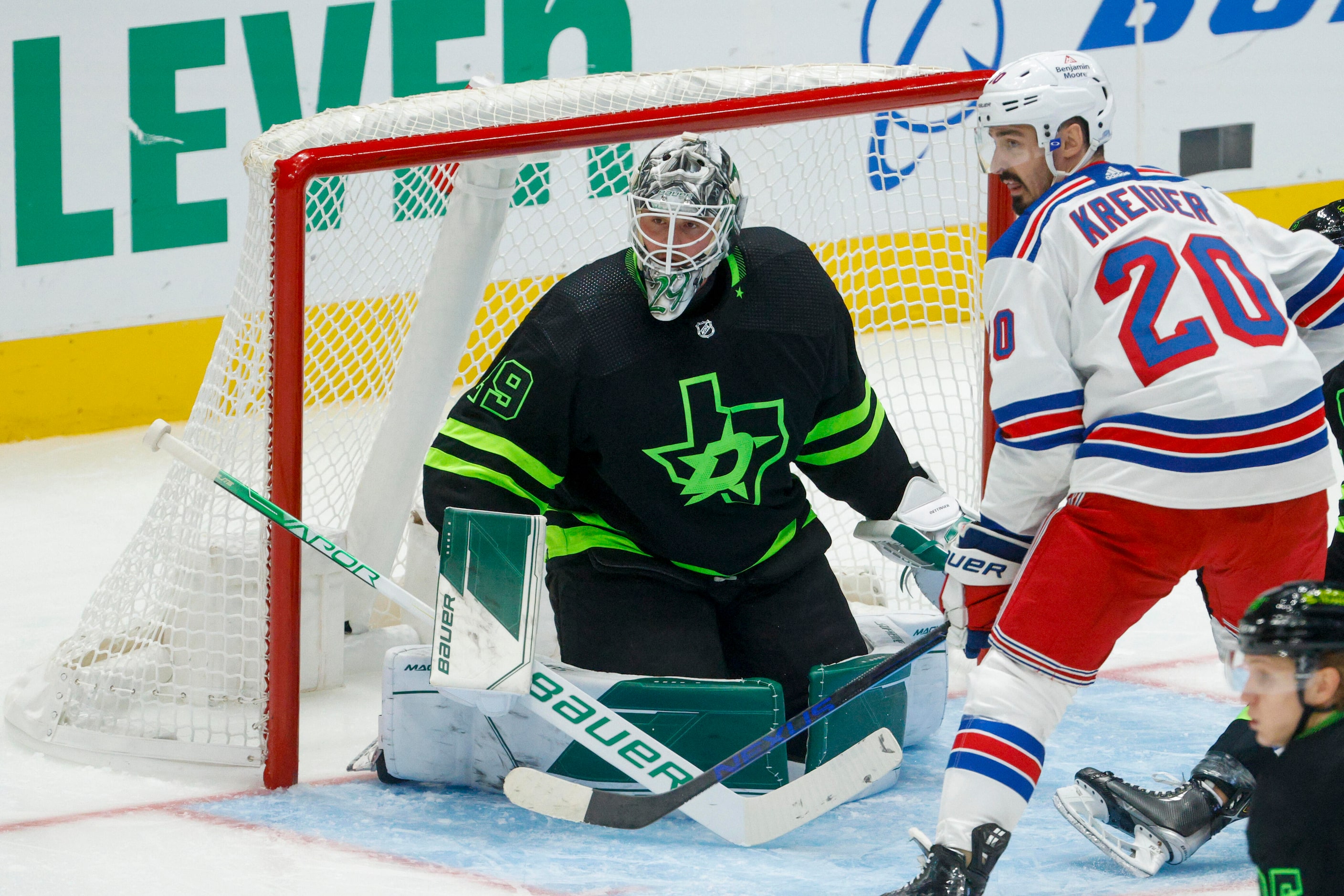 Dallas Stars goaltender Jake Oettinger (29) watches the puck alongside New York Rangers left...