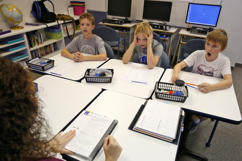 Andrew Dunn, (from left) Cody Williams and William Minich study the alphabet with their...