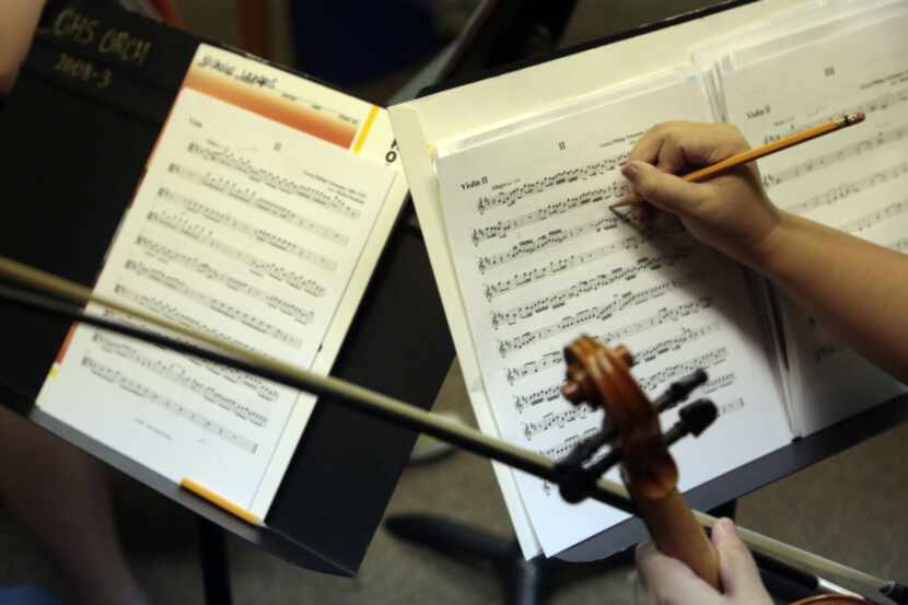 Violinist Tien Huynh, 16, makes notes on her music. ChamberWorks founder Marcus Pyle...