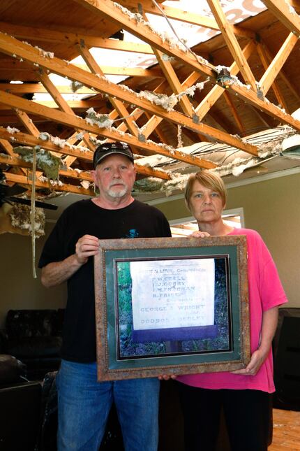 Rickey and Gina Dodson stand inside their home in Emory, Texas holding a photograph of a...