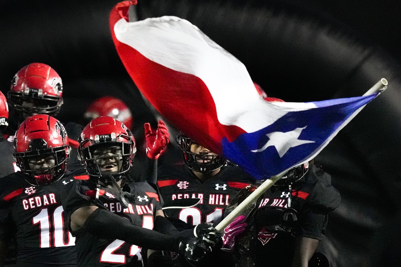 Cedar Hill defensive back Michael Tolbert (24) carries the Texas flag as he leads his team...