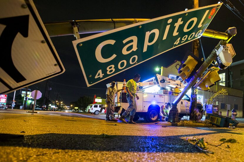 City of Dallas crews work to repair a traffic light that was knocked over into the...