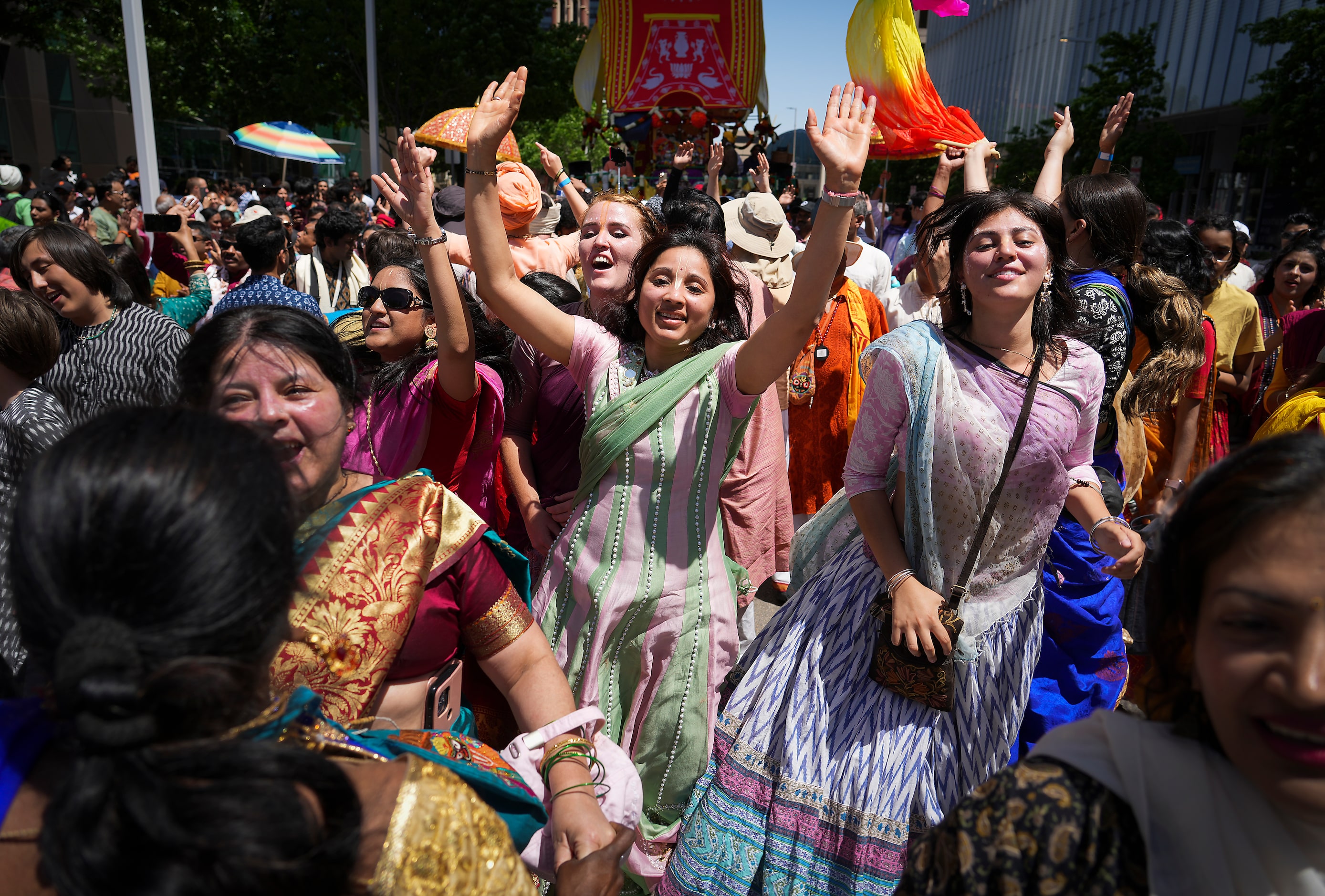 Revelers participating in the Ratha Yatra parade dance down Ross Avenue downtown during the...