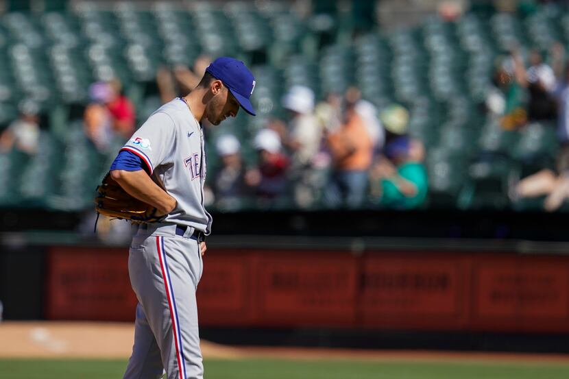 Texas Rangers relief pitcher Brett Martin reacts after he gave up a solo home run to Oakland...