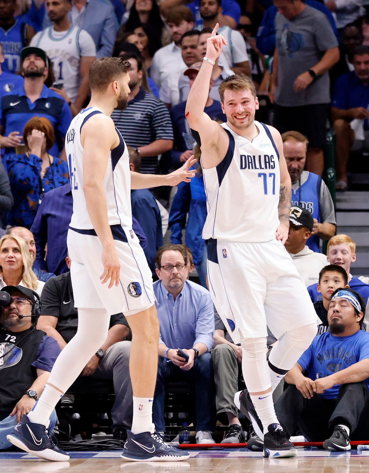 Dallas Mavericks guard Luka Doncic (77) raises his hand after committing a foul and cutting...