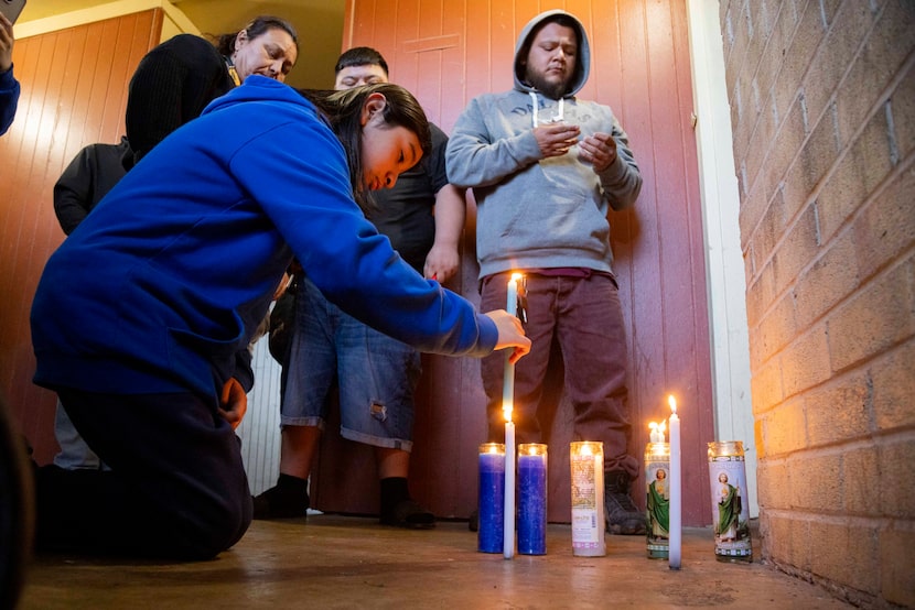 David Lopez, 12, places a candle in front of the door of his late cousin, Juvenal "Juvi"...