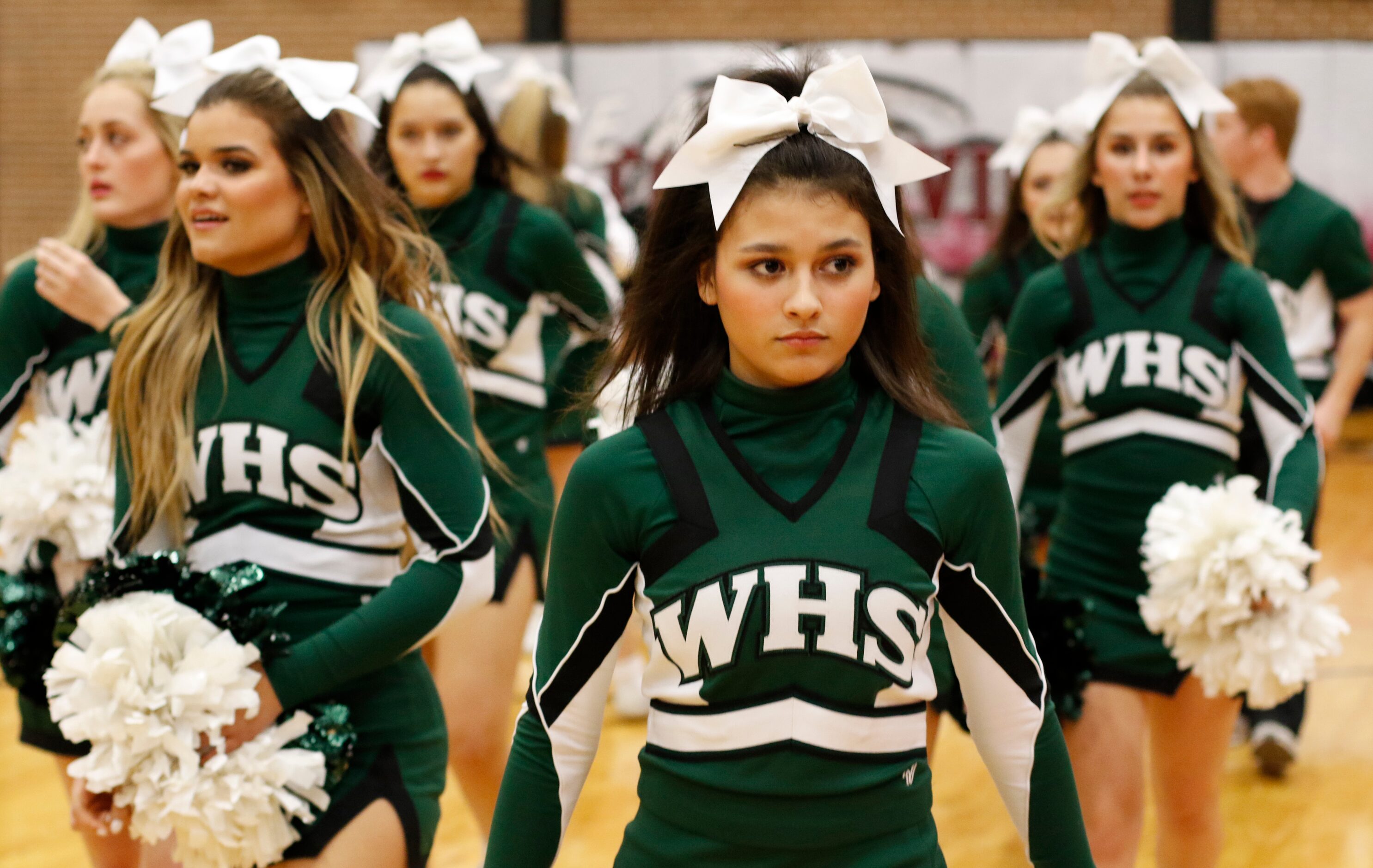 Members of the Waxahachie Indians varsity cheerleaders pause and listen as head coach Greg...