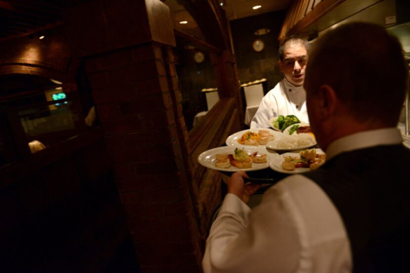 Executive Chef Valentin Echeverria, 28, hands off an order of food at Chamberlain's Fish...