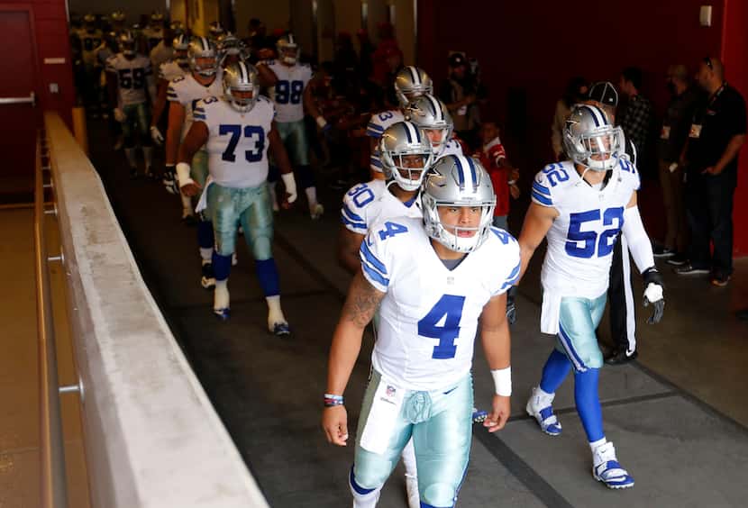Dallas Cowboys quarterback Dak Prescott (4) leads a group out to the field before playing...