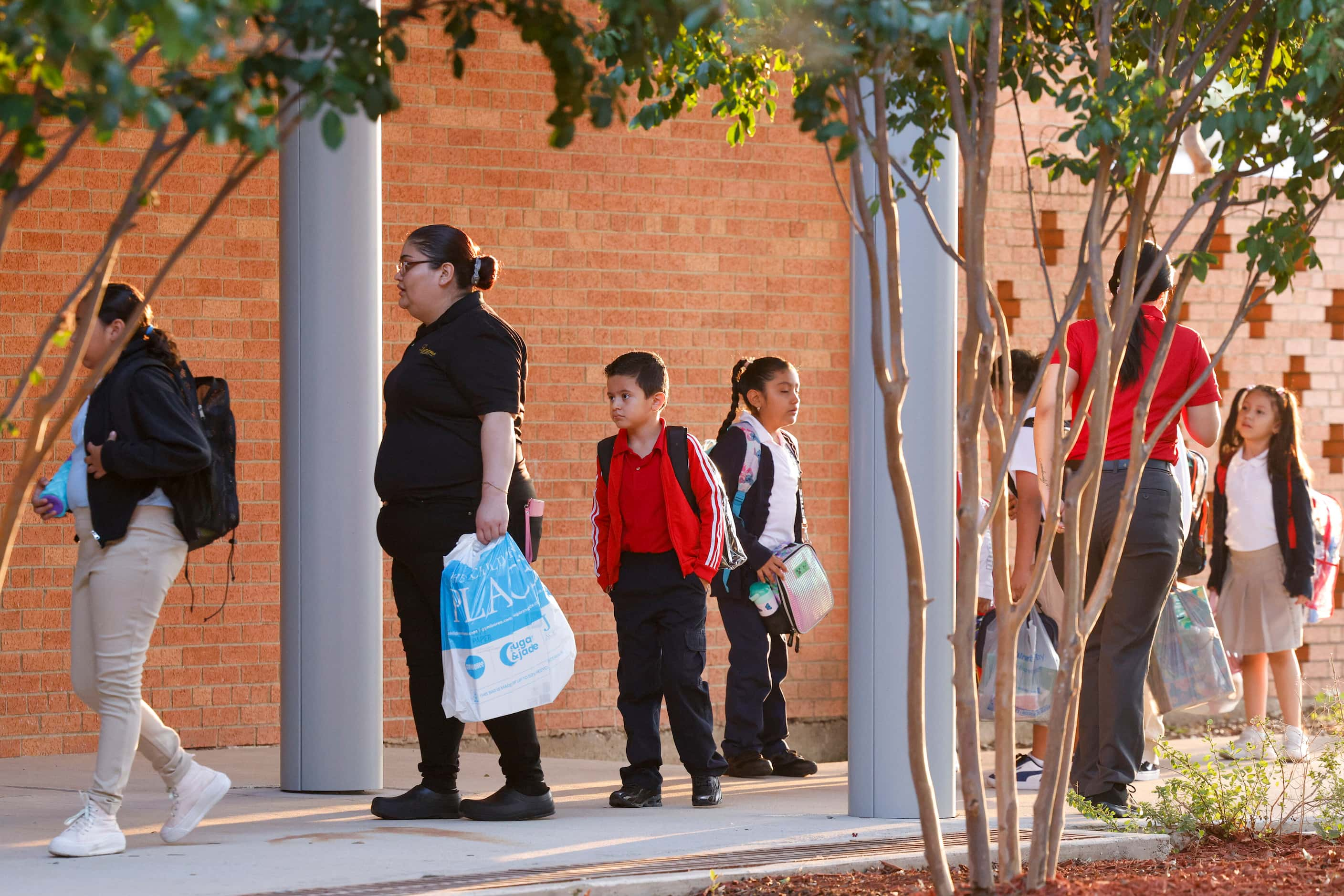 Students and family members make their way inside for the first day of class at John J....