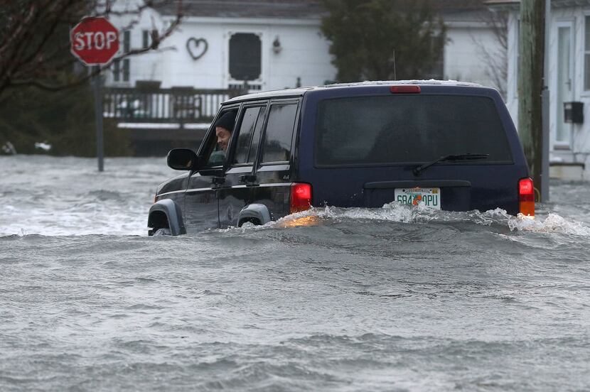  The driver of an SUV looks out of his window on a flooded 10th Ave. in North Wildwood,...