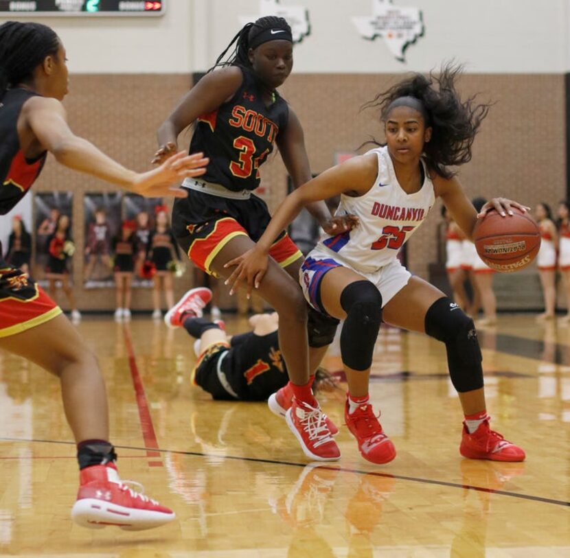 Duncanville guard Deja Kelly (25) drives to the basket as she is defended by an unidentified...