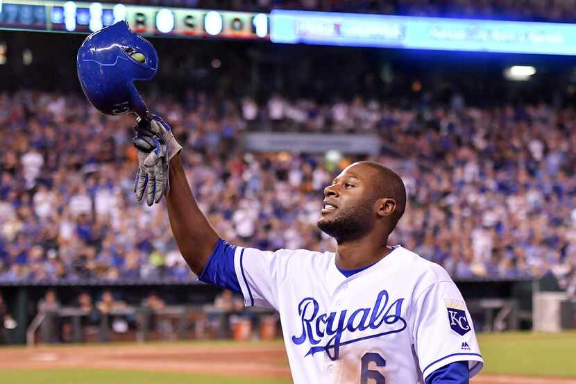 The Kansas City Royals' Lorenzo Cain tips his helmet to the cheering crowd as he comes out...