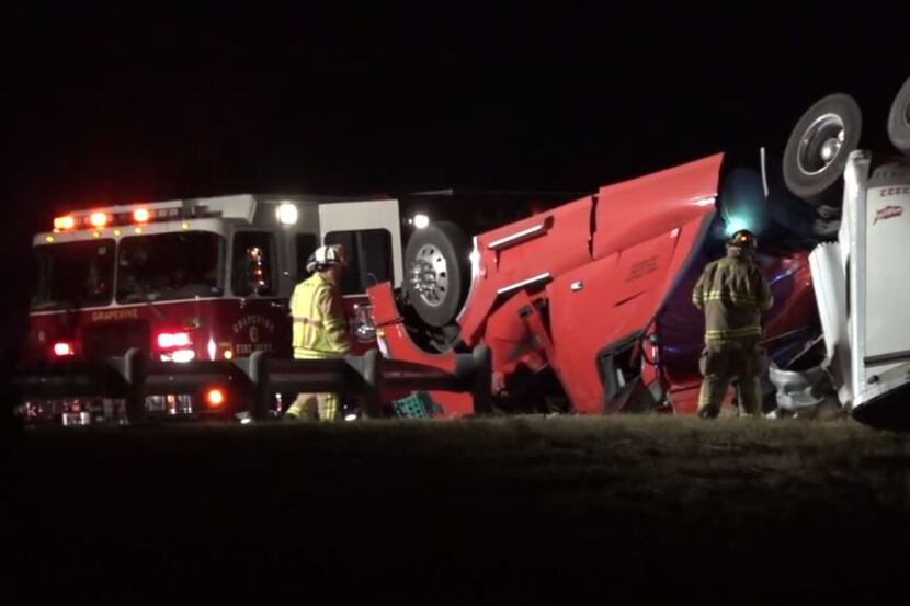 Grapevine firefighters assess the condition of an overturned 18-wheeler Tuesday morning. The...