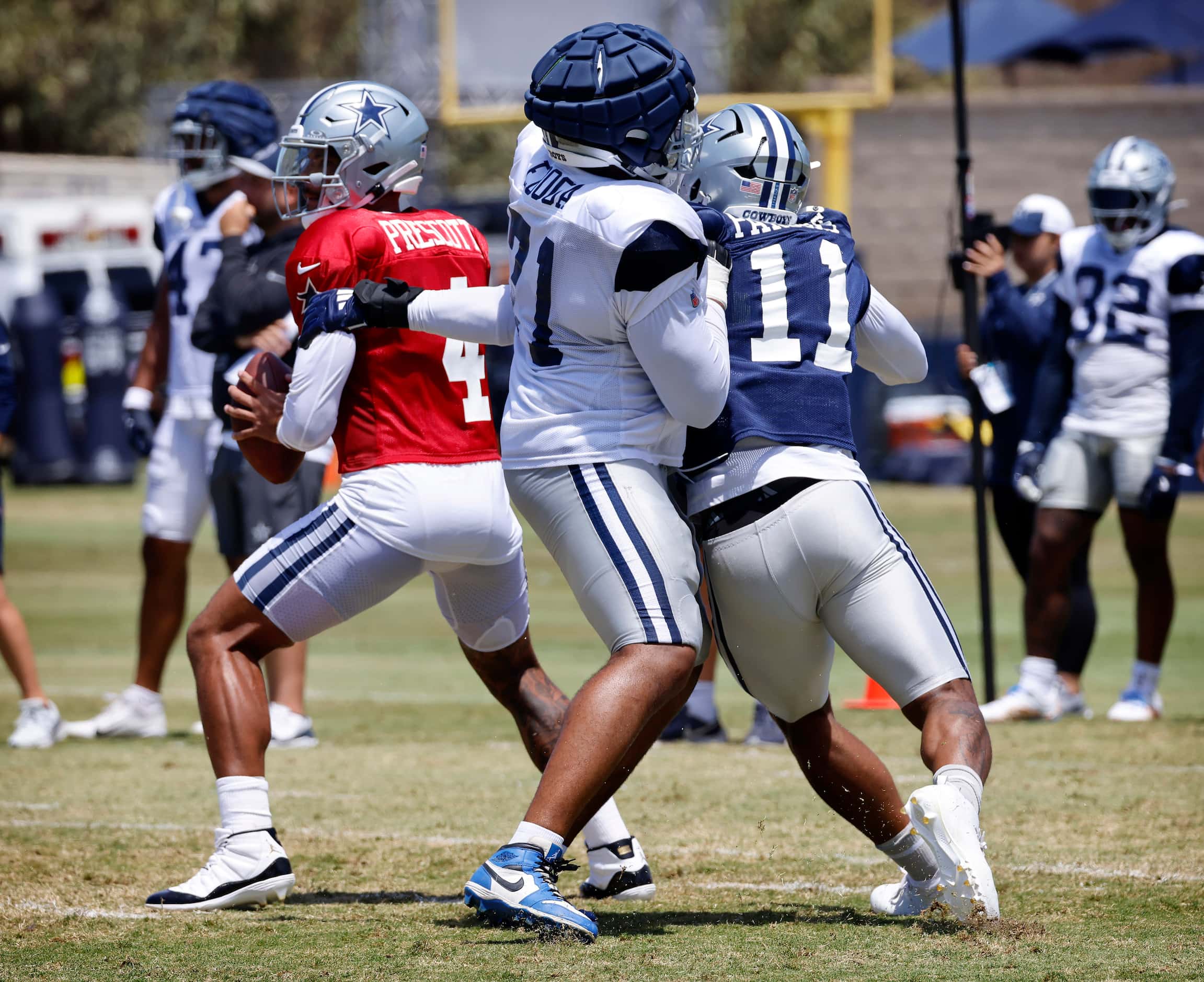 Dallas Cowboys linebacker Micah Parsons (11) grabs quarterback Dak Prescott (4) as he gets...