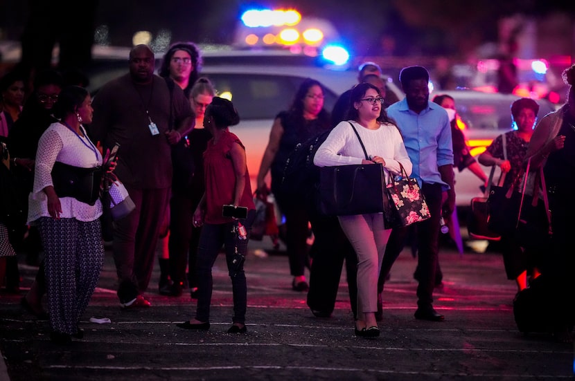 Workers evacuated from the offices of Dallas County Health and Human Services head toward...