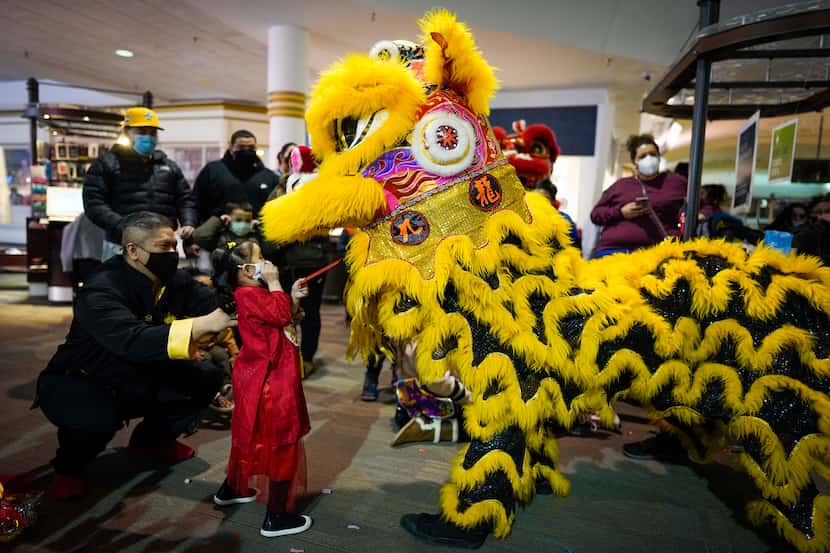 This file photo shows Averie Pham, 4, making an offering to performers with the Jiu Long...