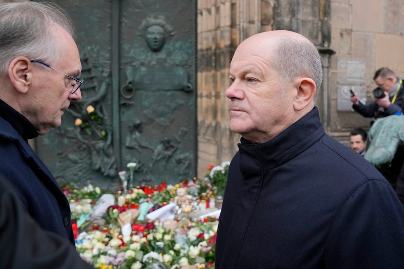 The Chancellor of Germany Olaf Scholz, right, arrives outside St. John's Church to lay some...