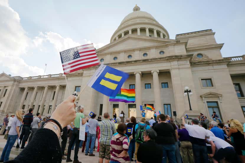 Demonstrators wave flags as they attend a rally at the Arkansas state capitol in Little Rock...