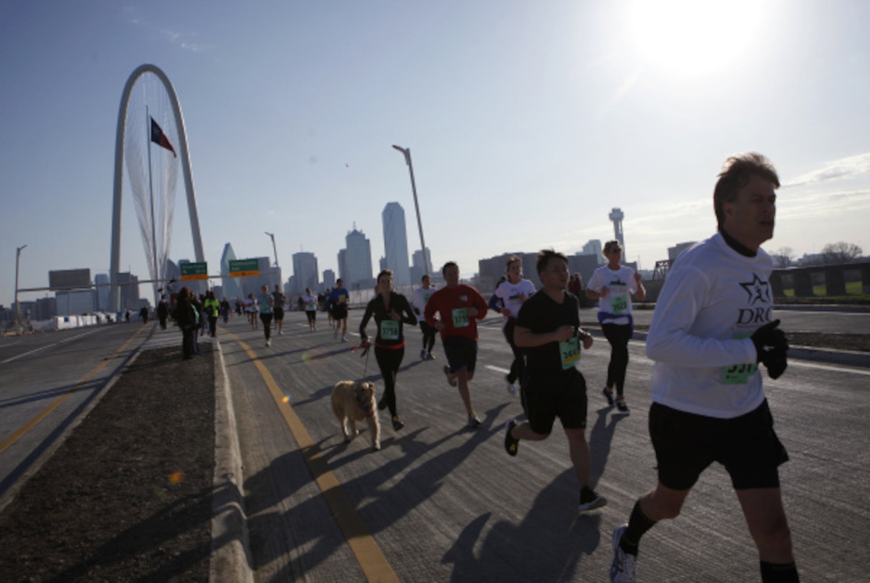 Participants run  toward the finish line at the west side of the Margaret Hunt Hill Bridge...