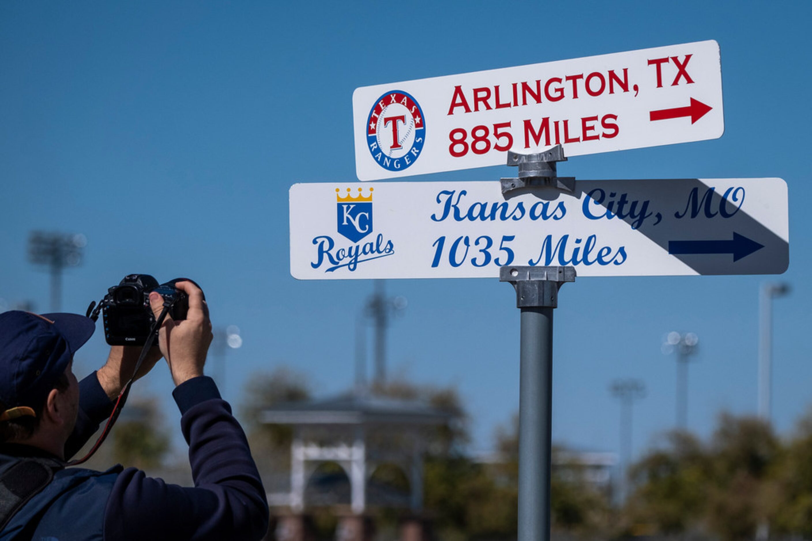 A fan takes a photo of signs showing the distances home for the Texas Rangers and the Kansas...