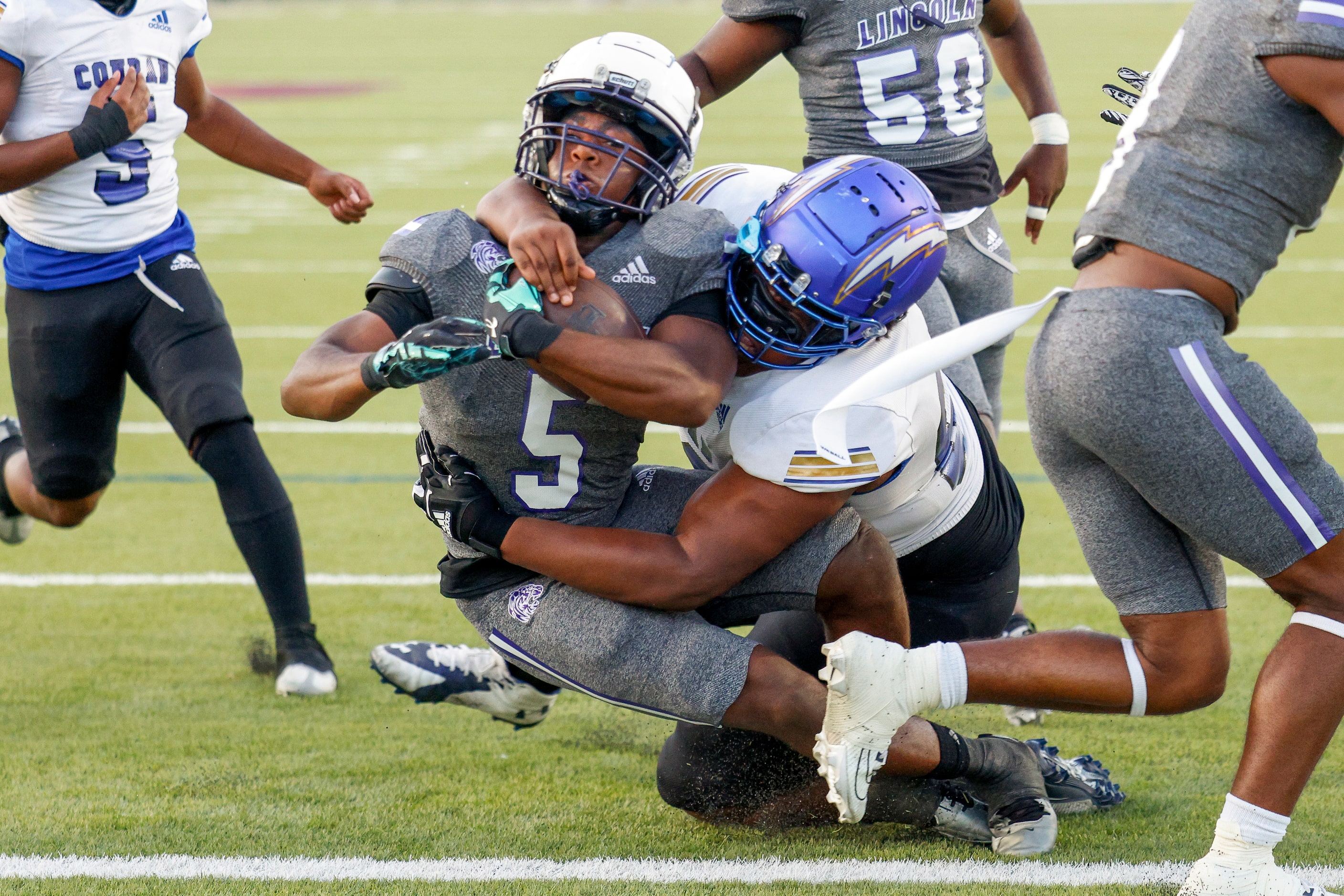 Lincoln running back Jarmon Jamon (5) rushes for a touchdown as he’s tackled by Conrad...