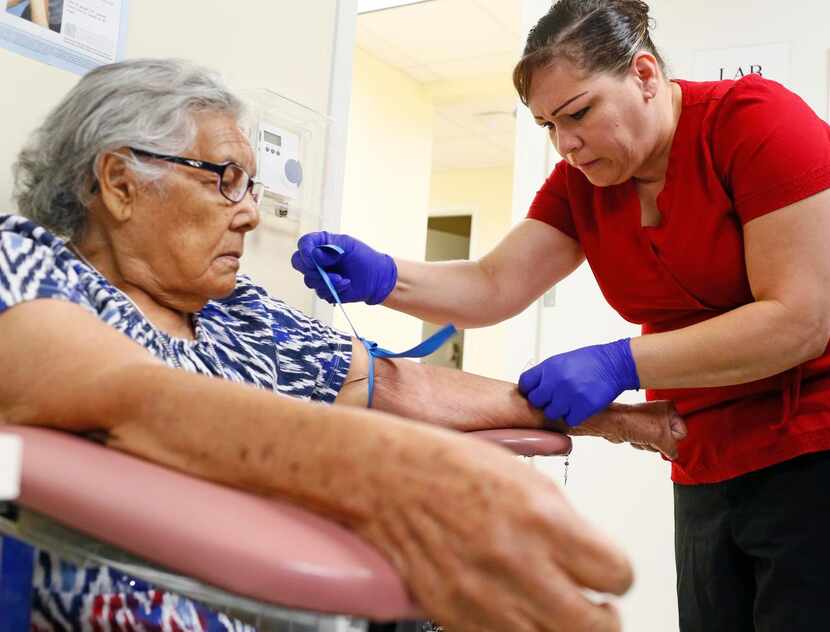 
Romualda Hernandez (left) has her blood taken by Teresa Carillo at Healing Hands Ministries...