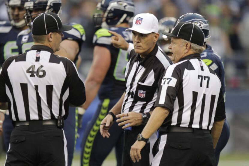 Officials Marc Harrod (46) and Mike Peek (77) conferred during the first half of Monday's...