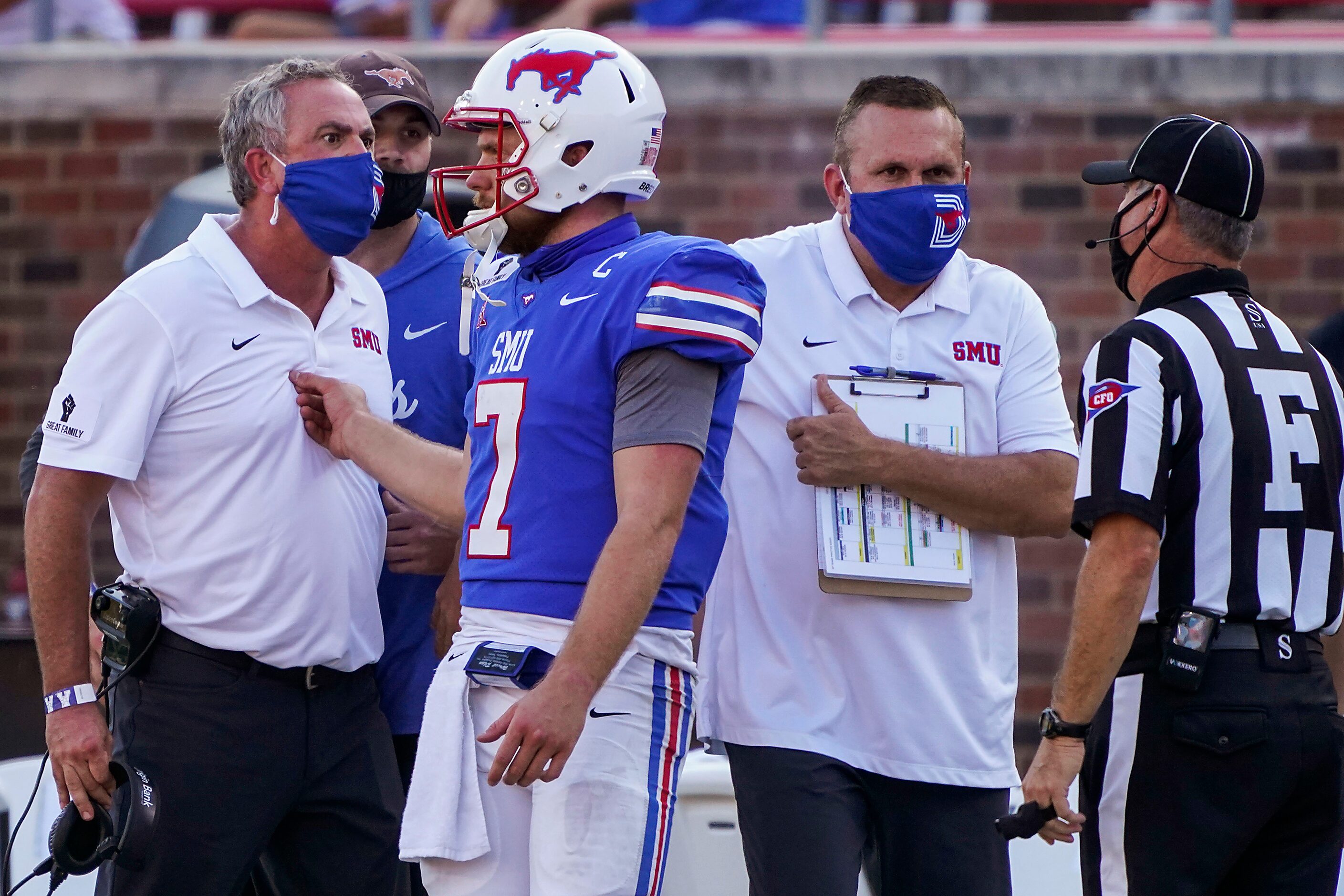 SMU quarterback Shane Buechele steps in to separate head coach Sonny Dykes from a referee...