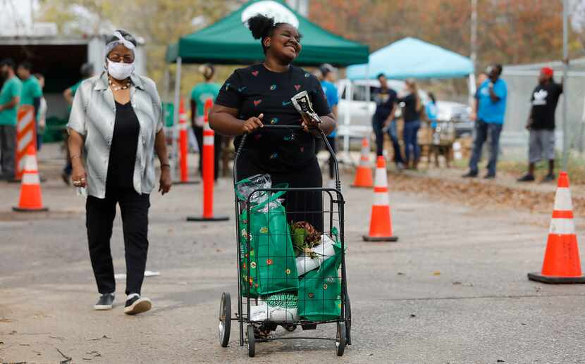 Clara Lang (left), 76, of Dallas, and her granddaughter Chyna Lang, 11, walk home with fresh...