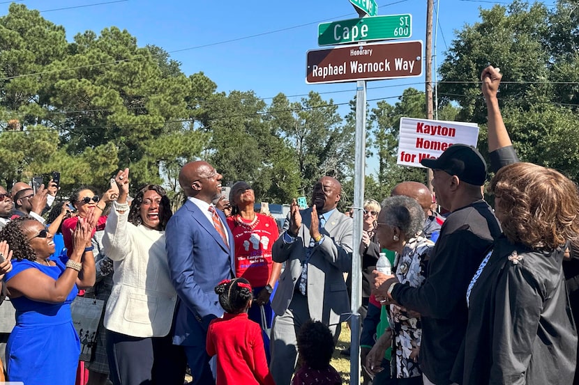 U.S. Sen. Raphael Warnock, D-Ga., views a street sign during a ceremony naming a street in...