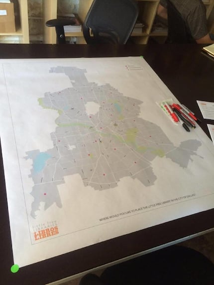A large map of Dallas stretches across a table in buildingcommunityWORKSHOP. Community...