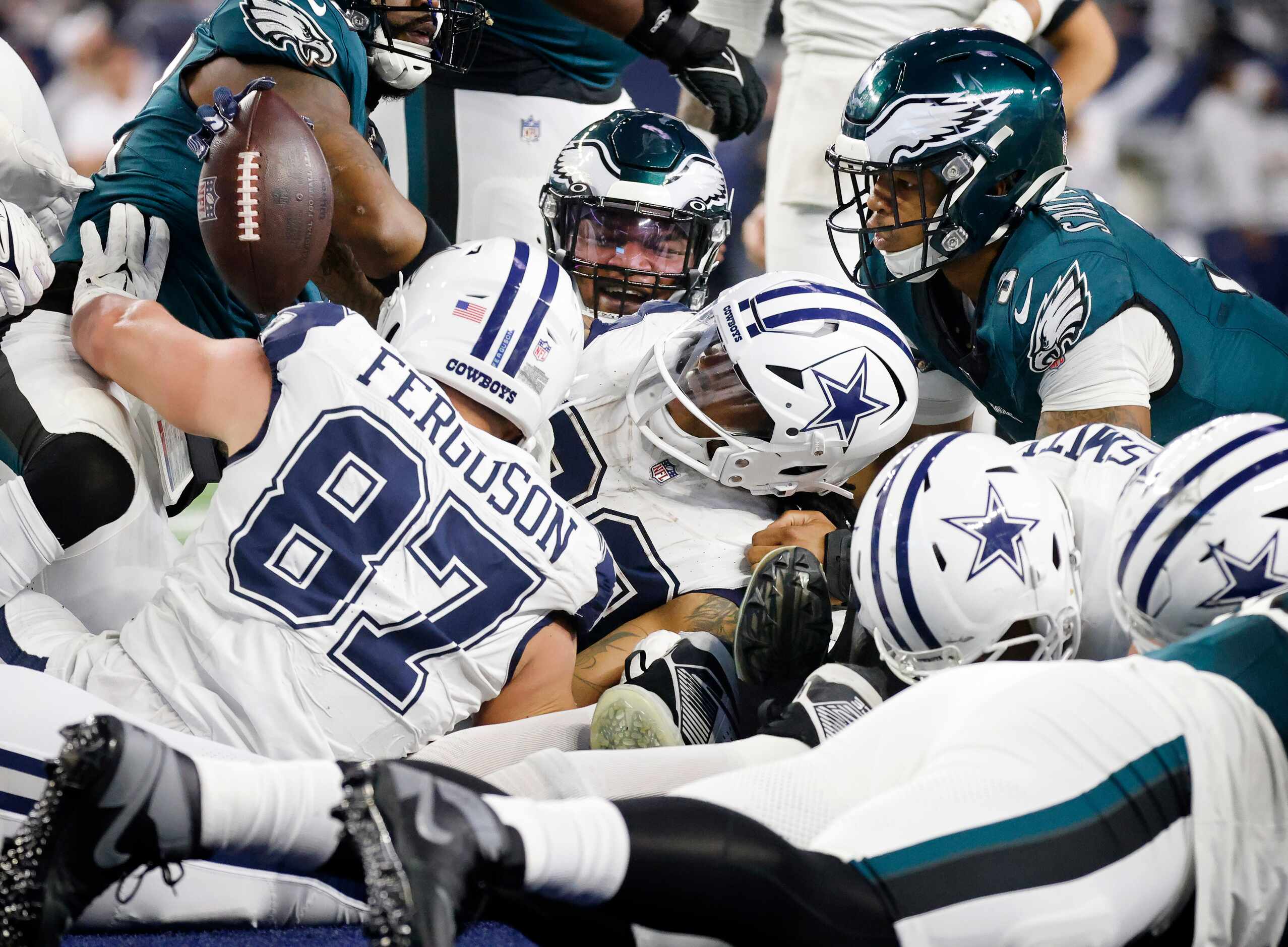 Dallas Cowboys running back Tony Pollard (20) raises the ball to show that he scored a...