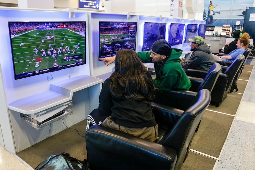 Travelers play various video games at Gameway inside Terminal E, Tuesday, Oct. 31, 2023, at...