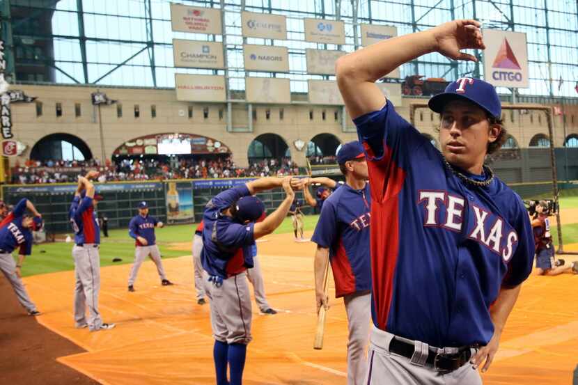 Texas pitcher Derek Holland loosens up before the Texas Rangers vs. Houston Astros season...