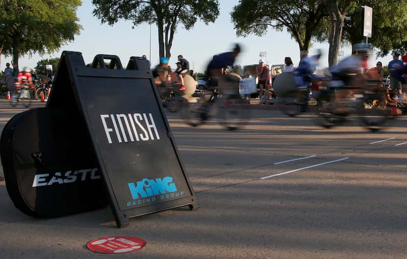 Cyclists race past the finish line during opening night for King Racing Group's season at...