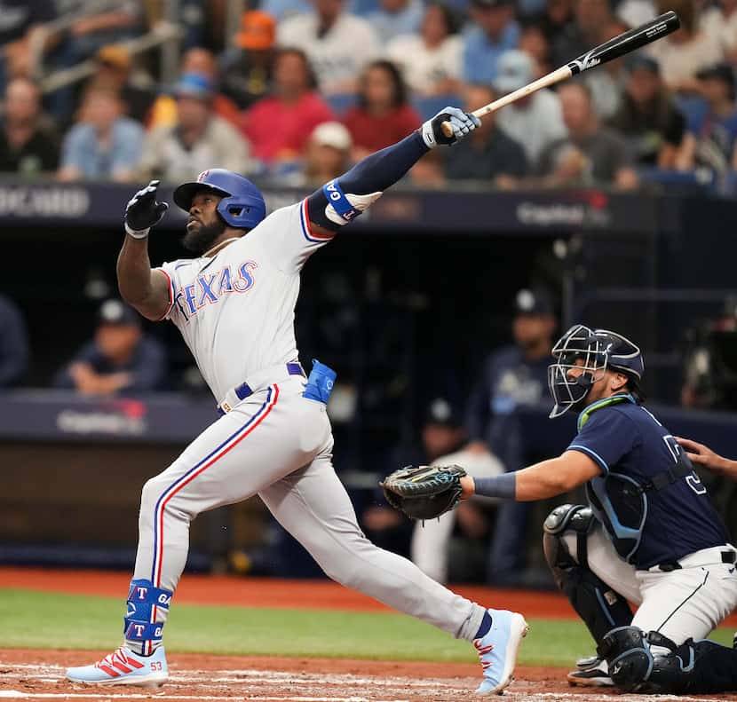 Texas Rangers right fielder Adolis Garcia follows through on a solo home run during the...