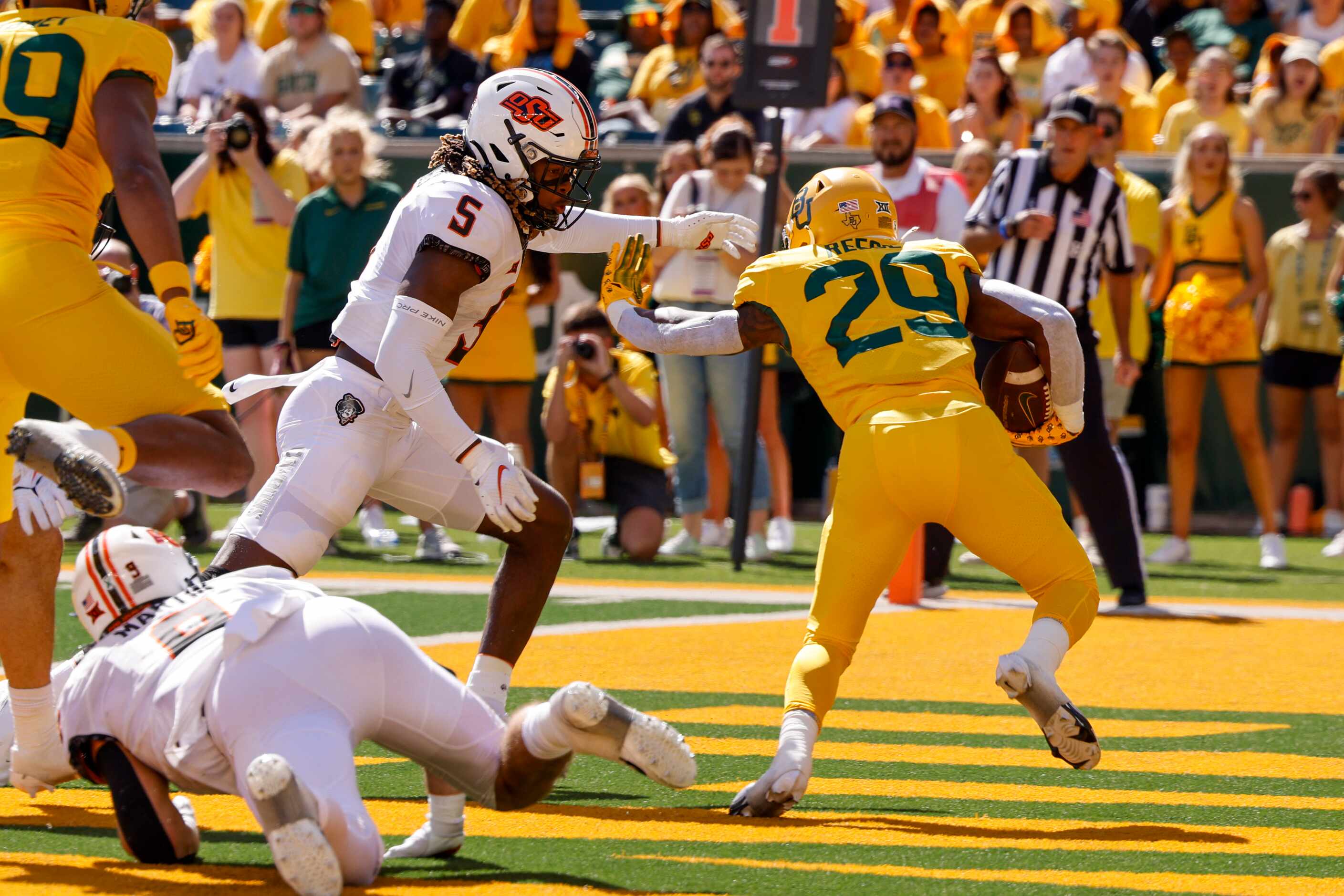 Oklahoma State safety Kendal Daniels (5) tackles Baylor running back Richard Reese (29) in...