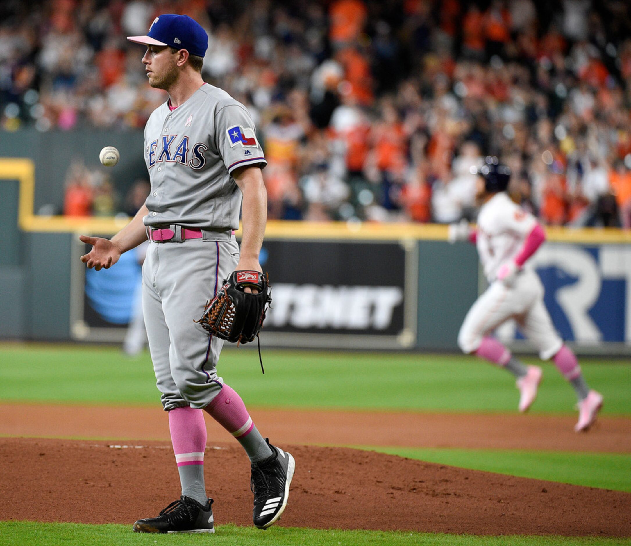 Texas Rangers starting pitcher Adrian Sampson, left, walks away from the mound as Houston...