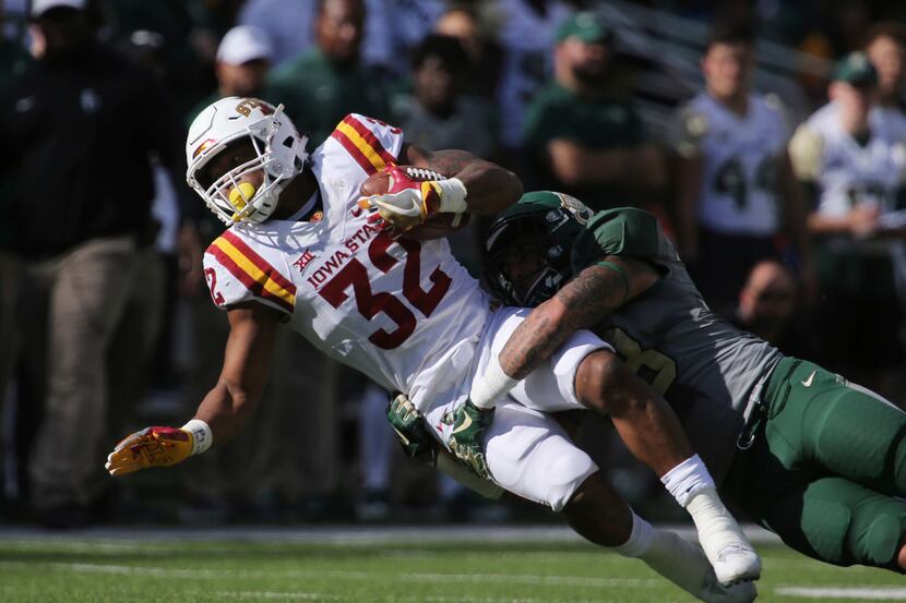 Iowa State running back David Montgomery, left, is pulled down by Baylor linebacker Jordan...