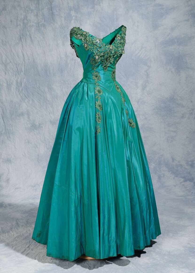 
This satin teal gown embellished with sequins and rhinestones is included in “Made...