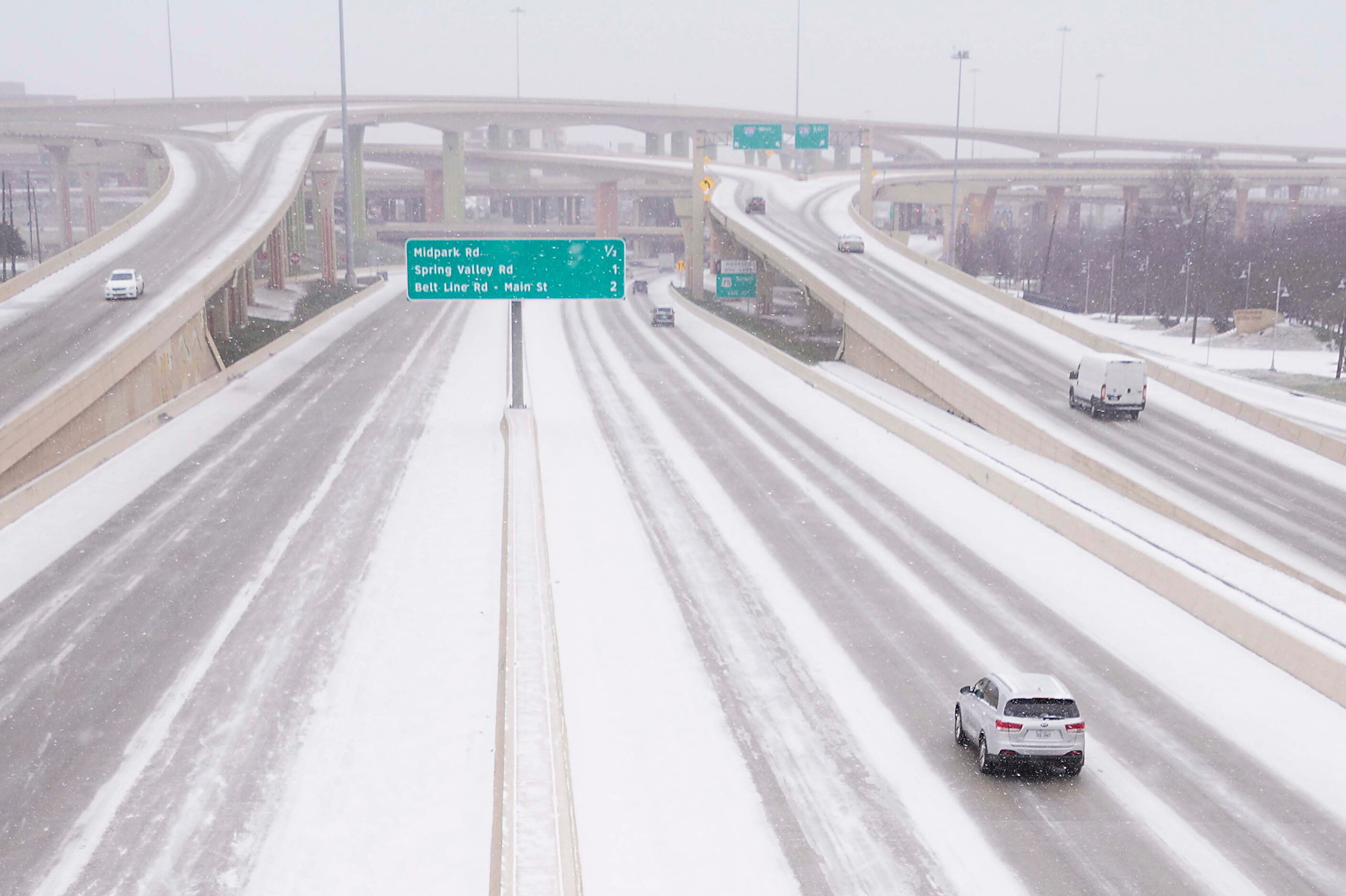 Traffic moves through snow on US-75 near the High Five interchange as a winter storm brings...