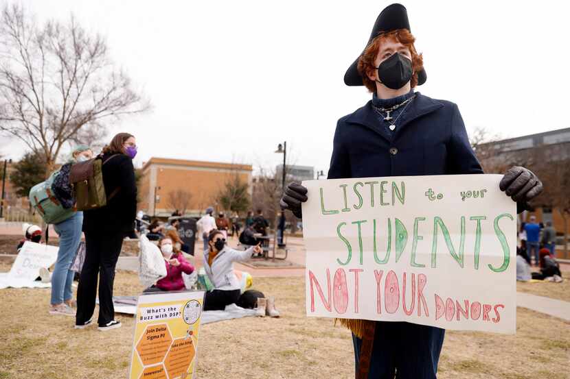 Caleb Matchett, a junior at the University of North Texas, quietly protests Thursday along...