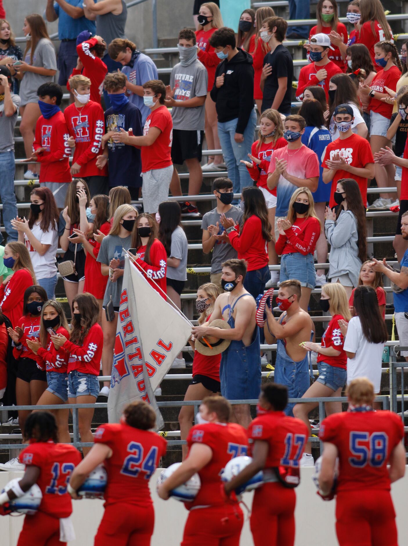 The Midlothian Heritage Jaguars student section stand and pause for the playing of the...