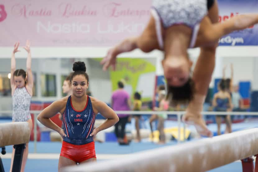 Gymnast Konnor McClain, 17, watches teammates practice on the balance beam during her...
