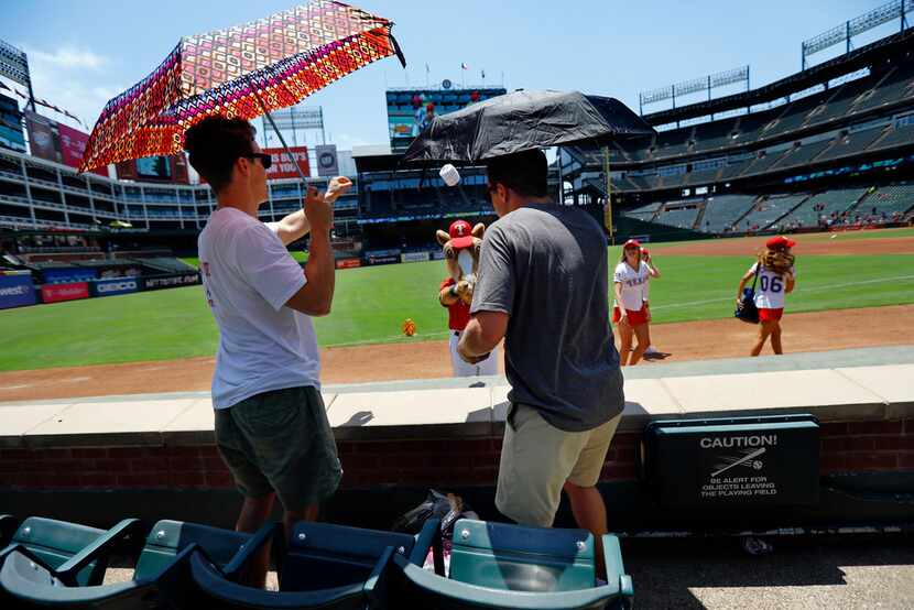 Texas Rangers fans Tom Hamilton of Plano (left) and Peter Brown of Knoxville, Tenn., catch a...