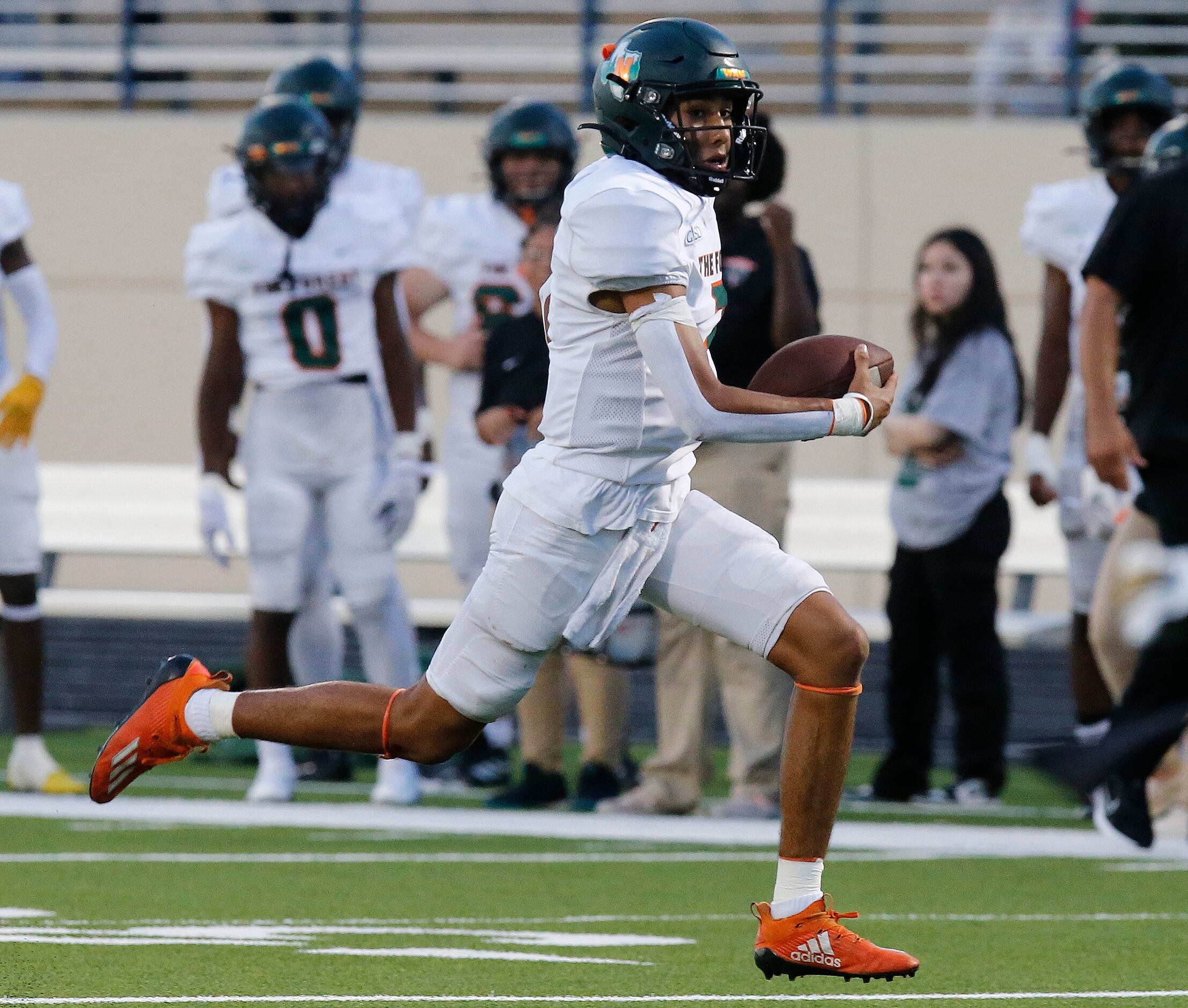 Naaman Forrest High School quarterback Deangelo Perales (7) keeps the ball and runs for a...