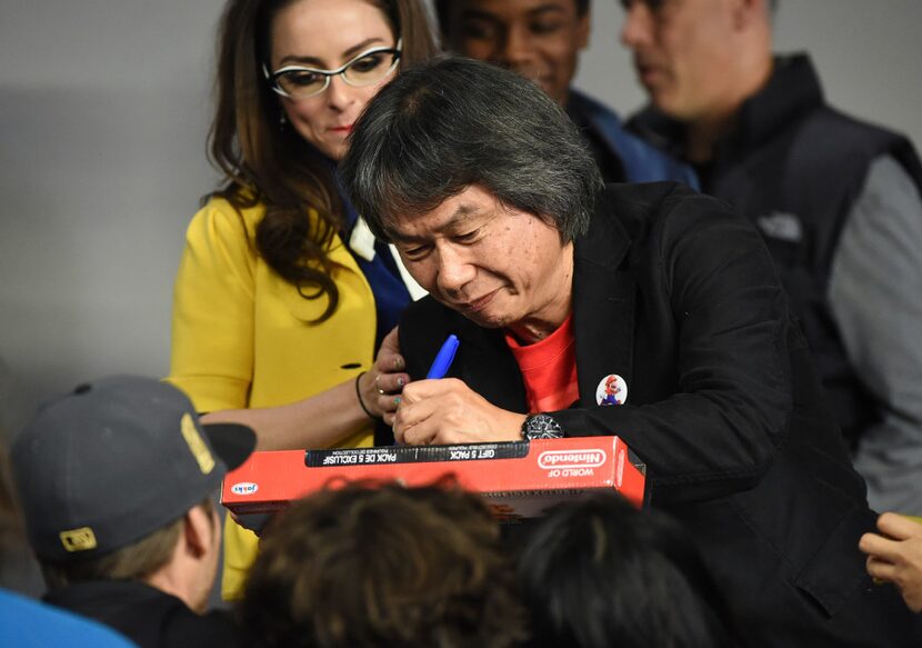 Japanese video game designer and producer Shigeru Miyamoto signs autographs during an...