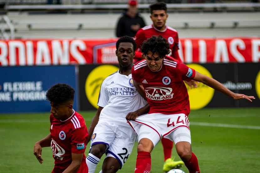 Johan Gomez (44) of North Texas SC is pulled back by Nathan Simeon (28) of Orlando City B....