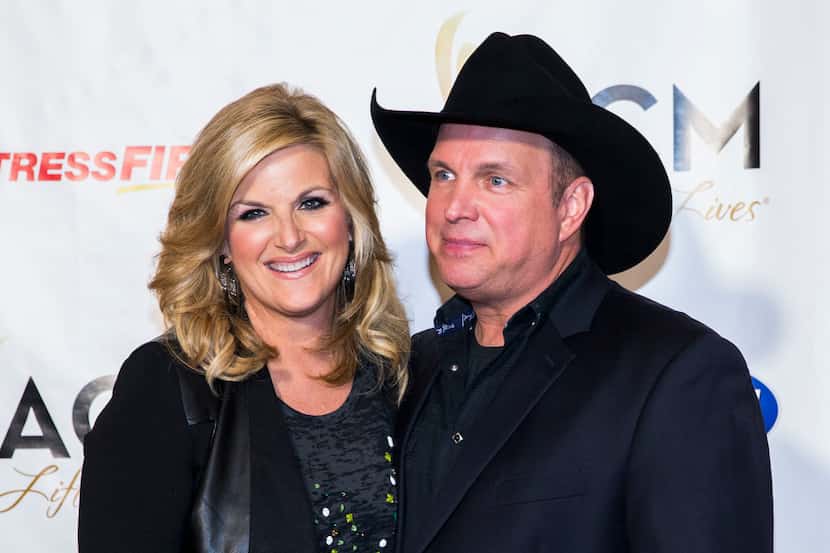 Country music artists Trisha Yearwood and Garth Brooks pose for photos on the red carpet at...